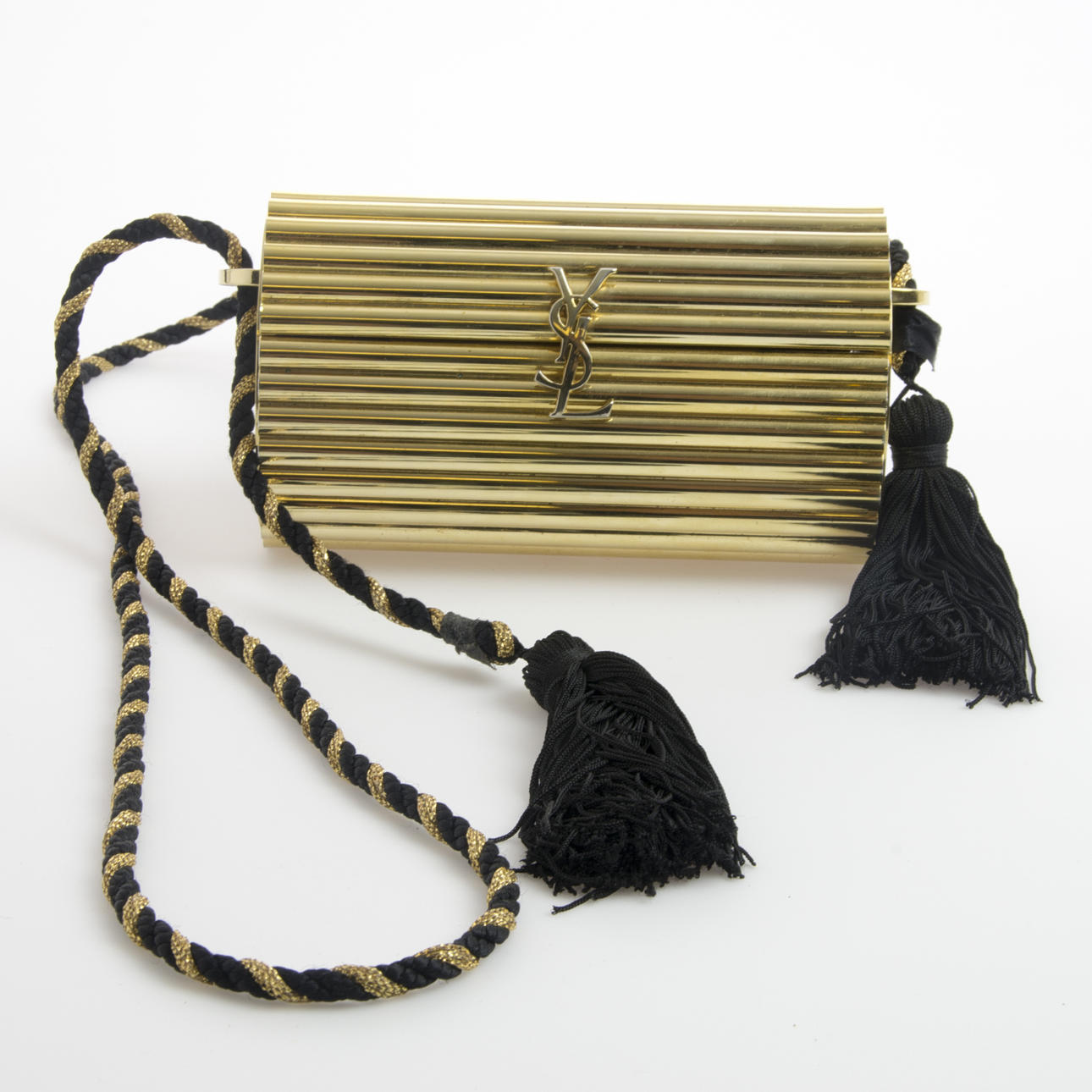 AFTONVÄSKA Yves Saint Laurent, gulmetall med tvinnat band i guld och svart med tofsar.