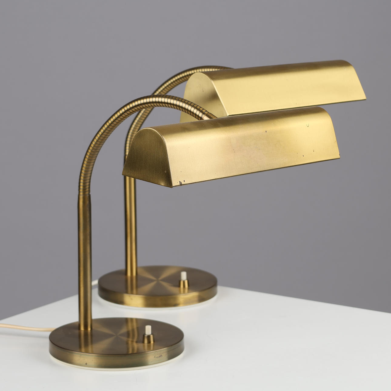 A pair of table/piano lamps with a brass flex arm, second half of the ...