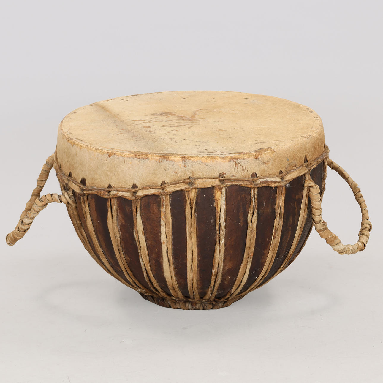 Stor afrikansk trätrumma och sträckt getskinn.