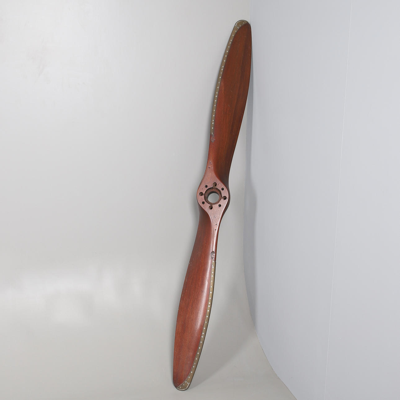 A TWIN BLADED WOODEN PROPELLER WITH BRASS LEADING EDGES. Weapons ...