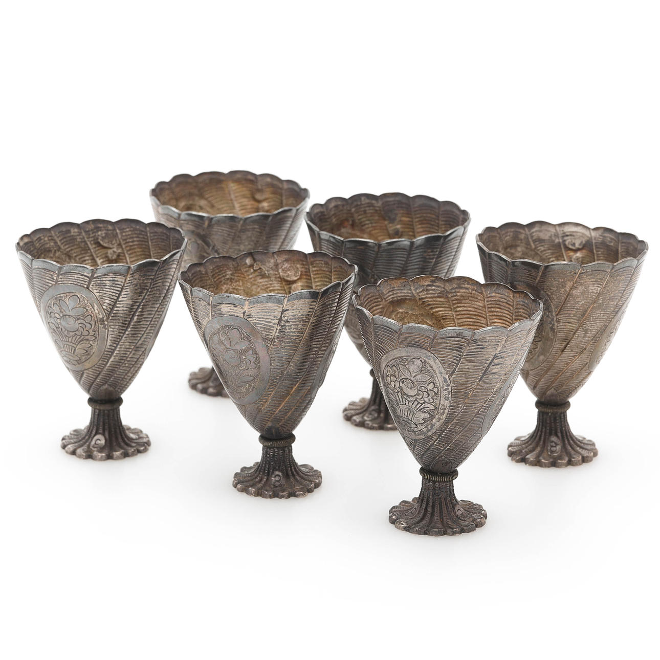 A set of 6 silver egg cups, oriental.