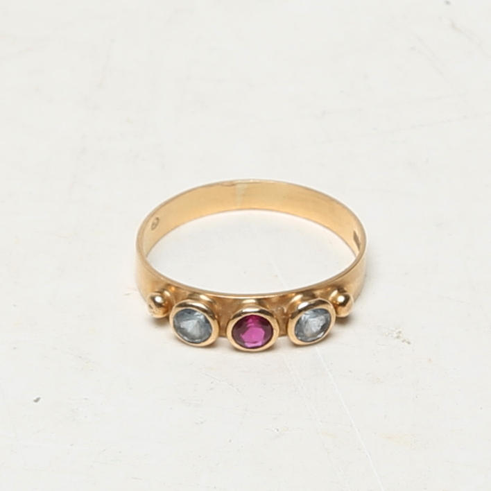 A 18K gold ring with precious stones.