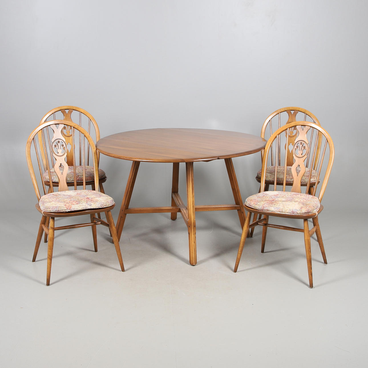 ERCOL ELM DROP LEAF TABLE WITH FOUR 'FLEUR DE LYS' DINING CHAIRS.