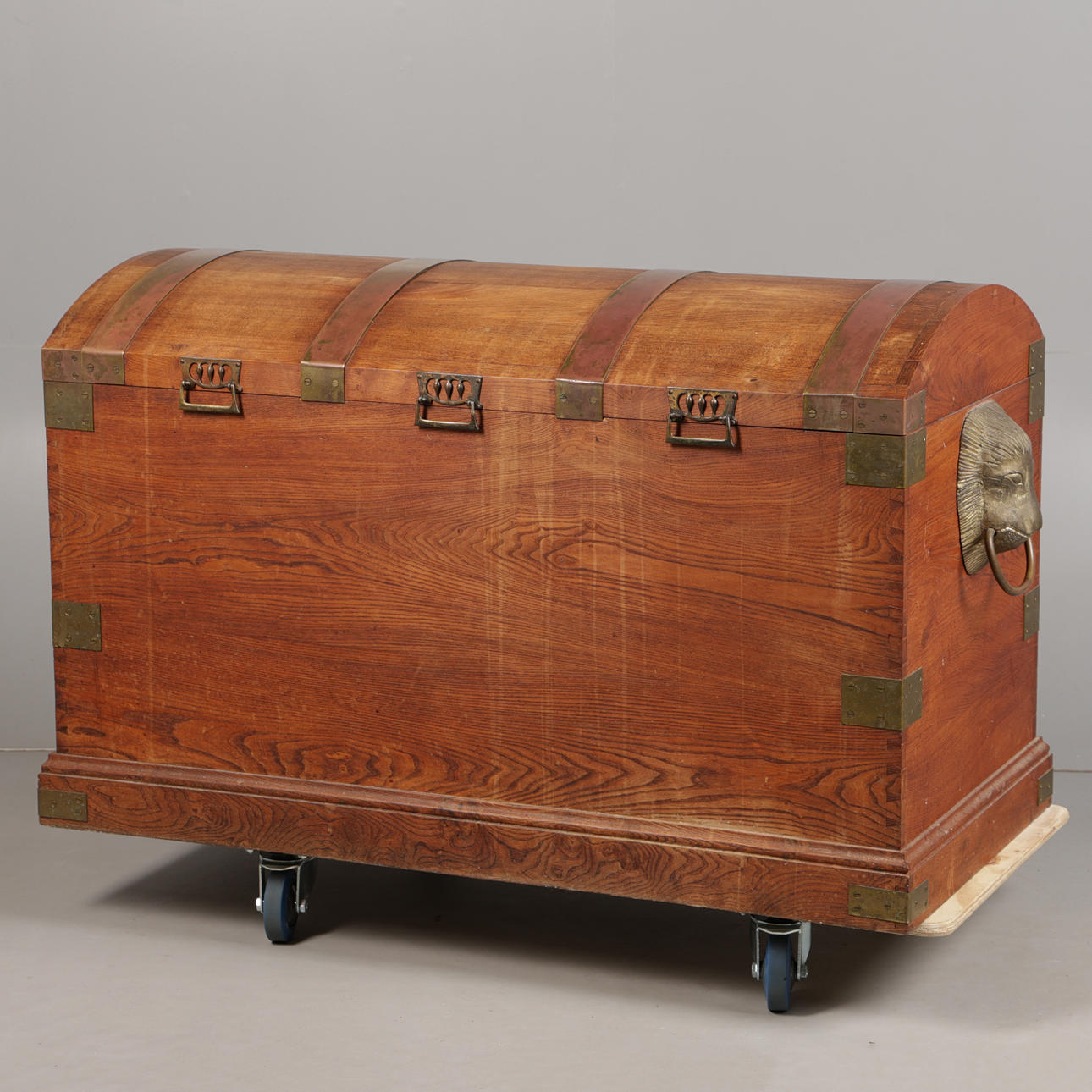 A BRASS BANDED OAK DOMED CHEST.