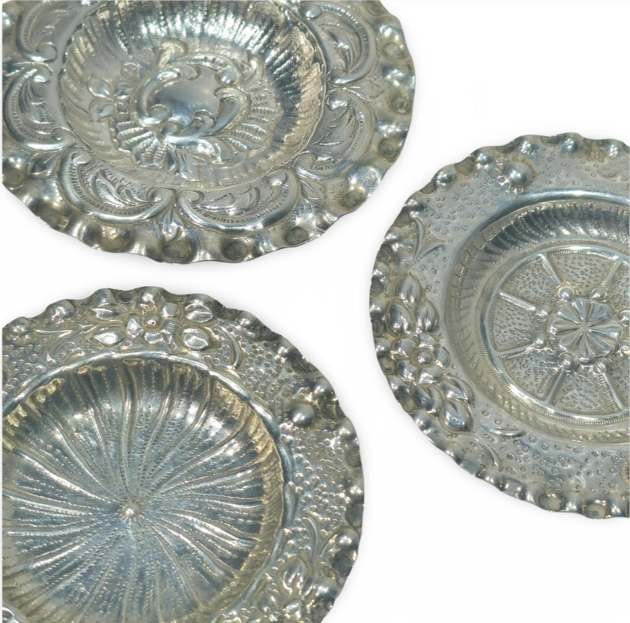 Three embossed plates in embossed silver.