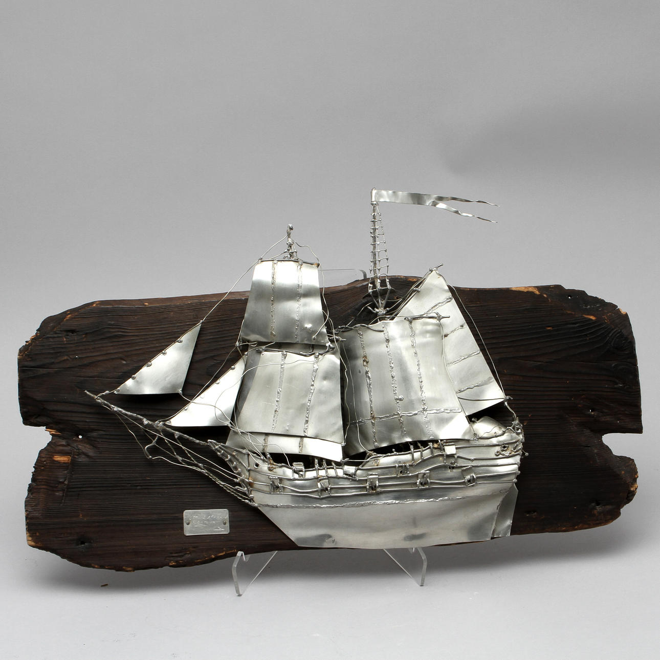 URBAN STRÖM. Väggrelief "Ostindiefarare", tenn monterad på trä, signerad och daterad -72.