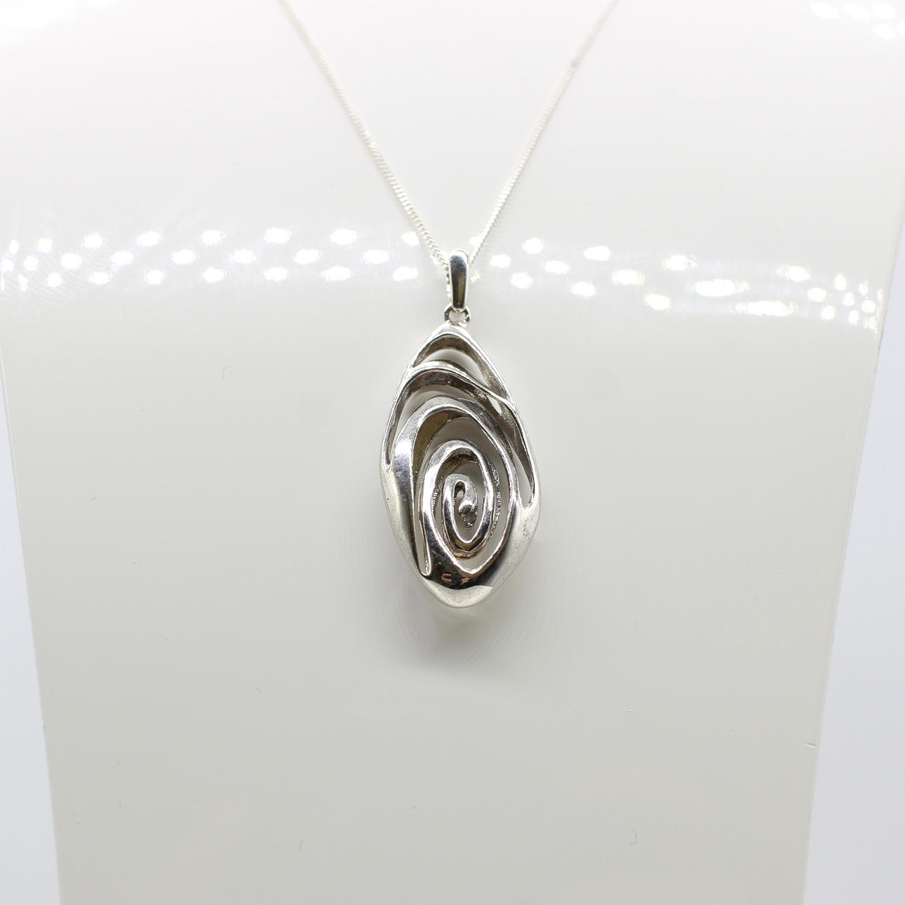SILVER PENDANT ON A SILVER CHAIN.