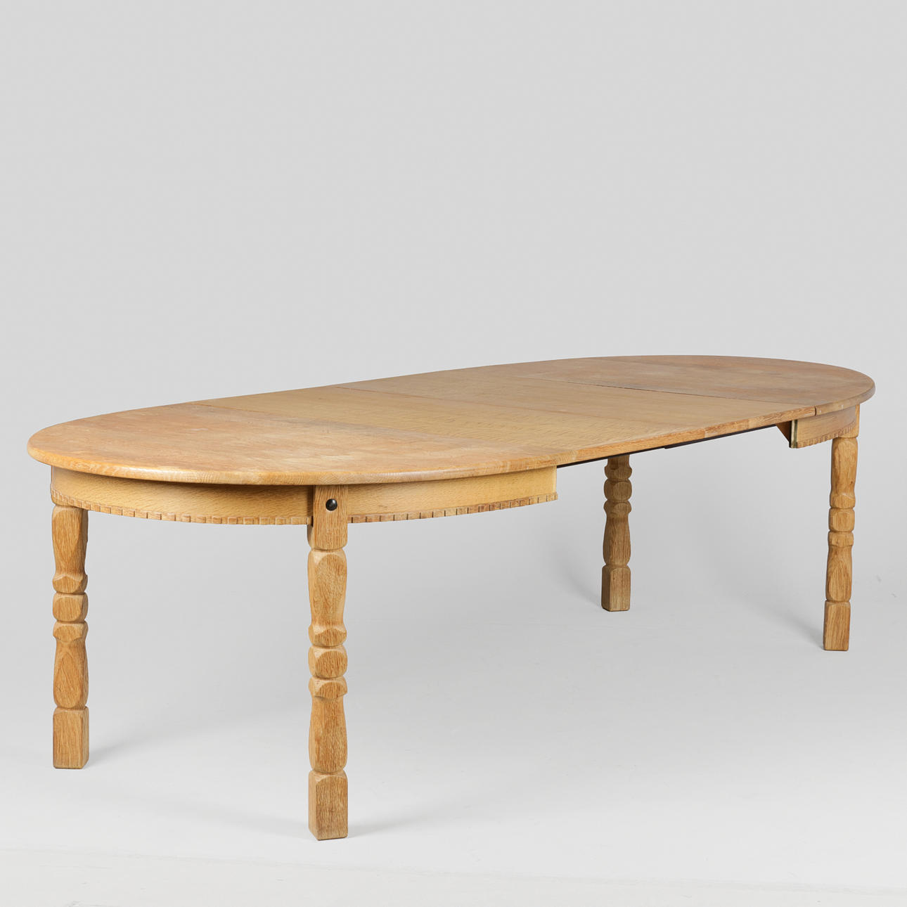 Oval oak dining table with pull-out and two additional plates, Kjærnulf style, Danish furniture manufacturer, Denmark, circa 1960/70s, (1+2).