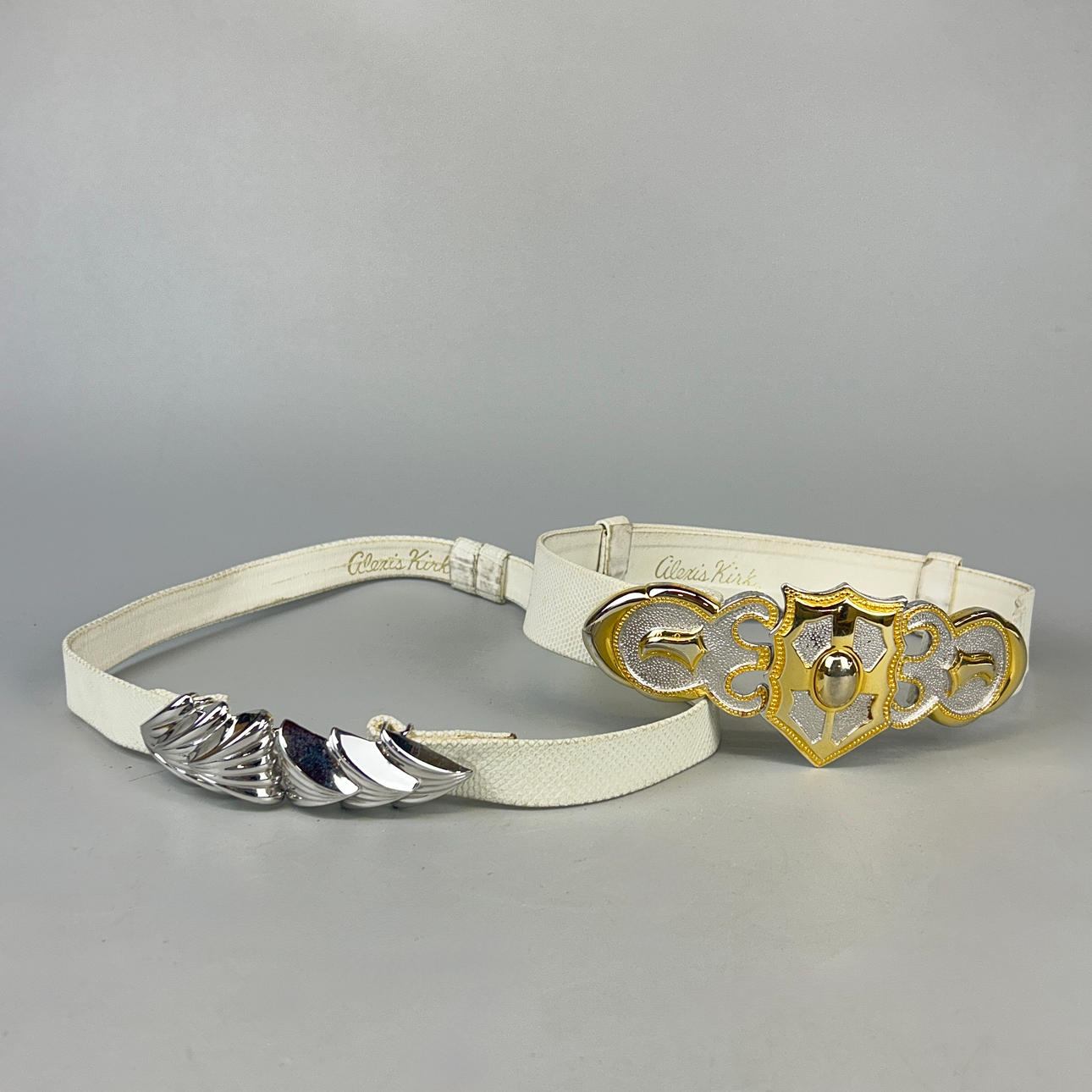 TWO ALEXIS KIRK SNAKE SKIN BELTS.