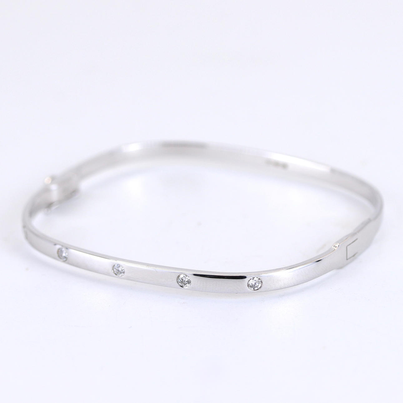CONTEMPORARY 9CT WHITE GOLD DIAMOND BANGLE.