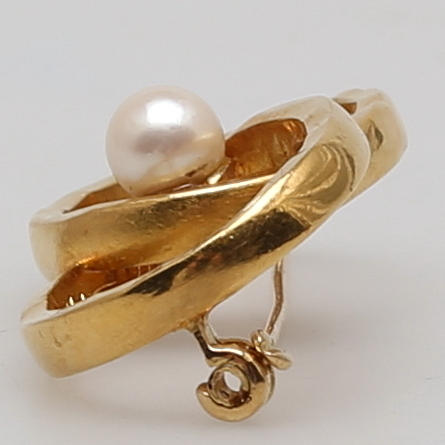 BROSCH i 23K gulguld, två bearbetade vigselringar besatt med pärla.