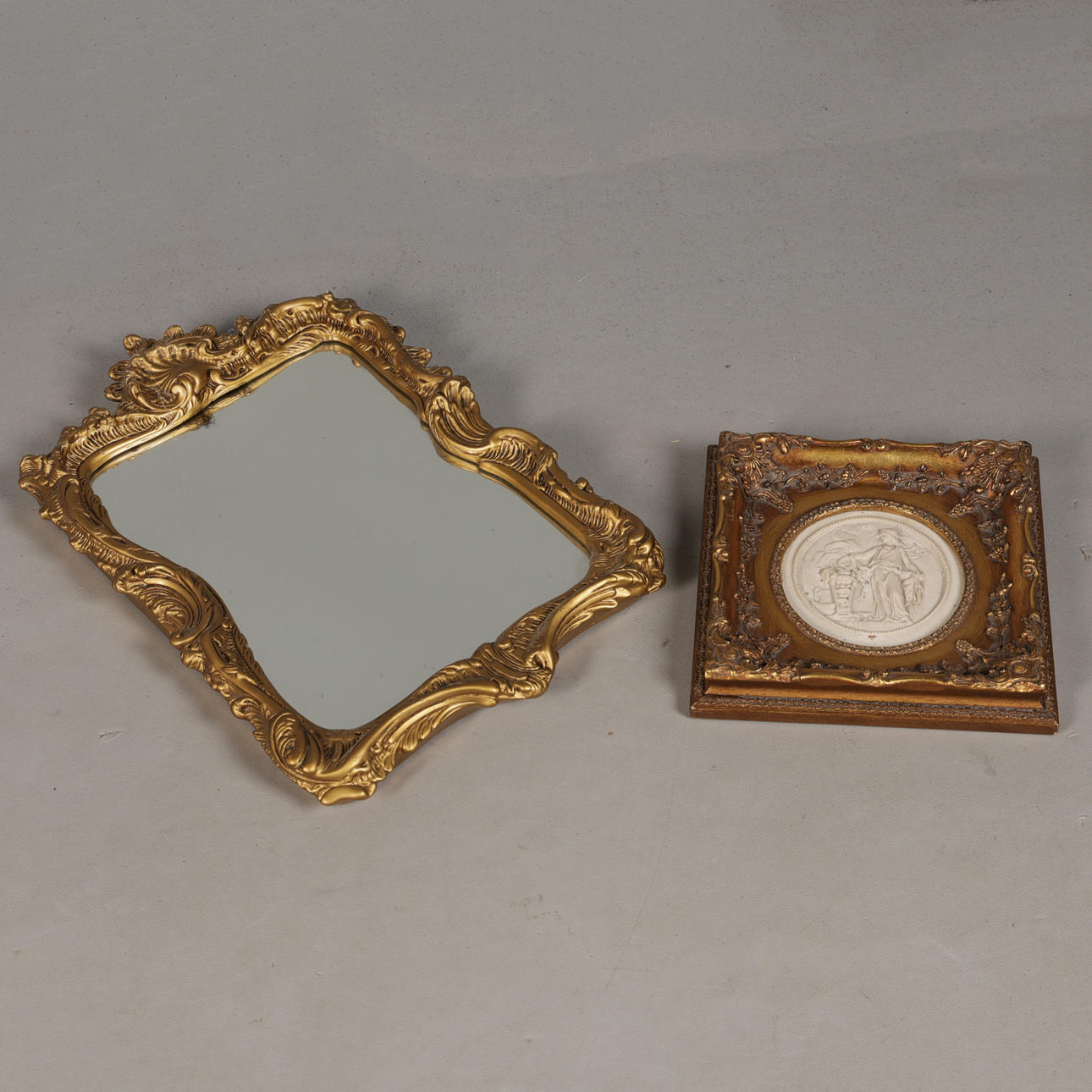 A GILT FRAMED ALABASTER PLAQUE AND A GILT MIRROR (2).