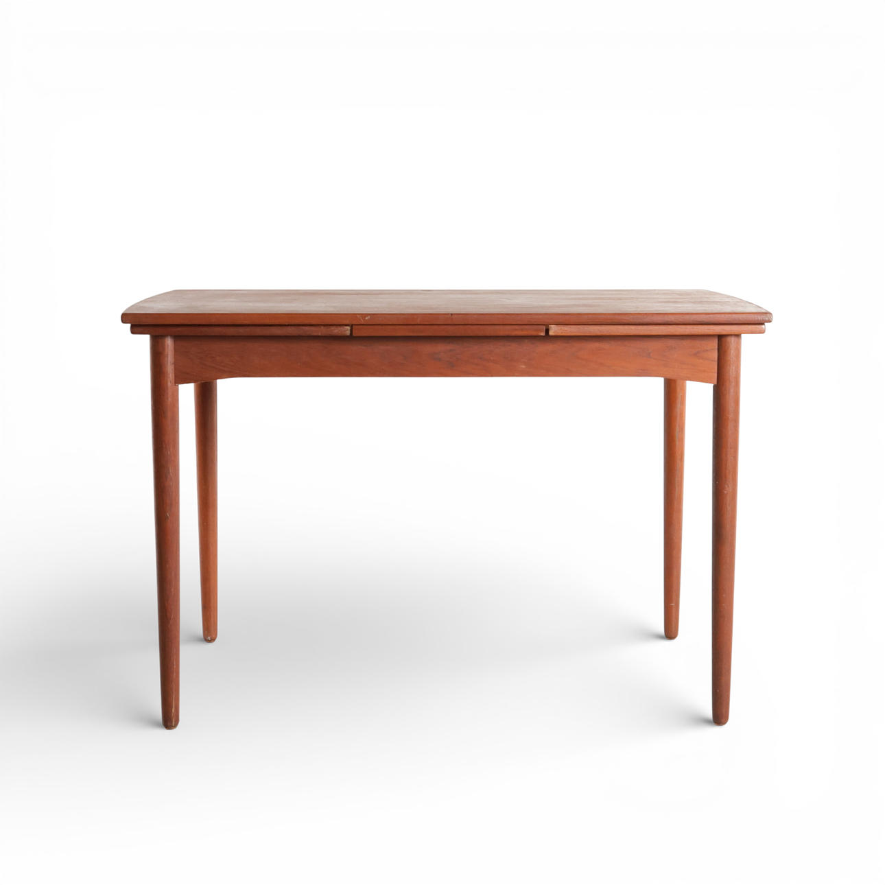 Rectangular teak dining table, plate with Dutch extraction, set on round tapered legs. Denmark, 1960s.