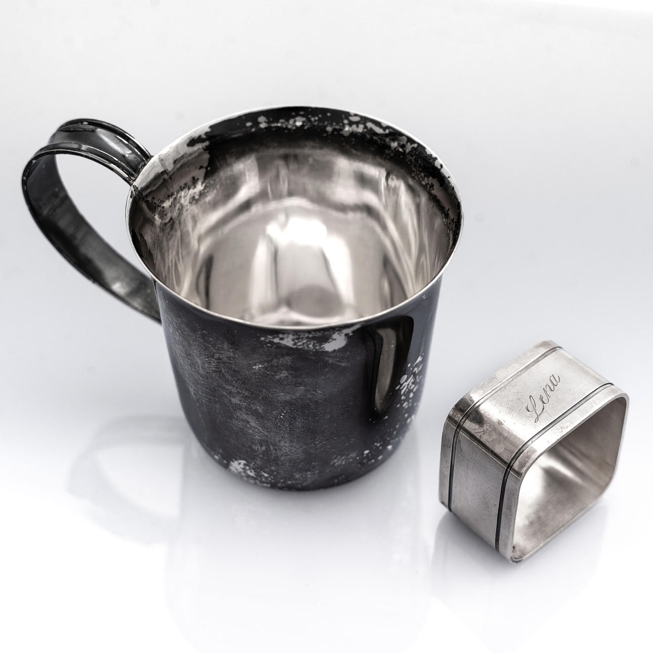A SILVER NAPKIN RING AND A MUG, 20th Century.