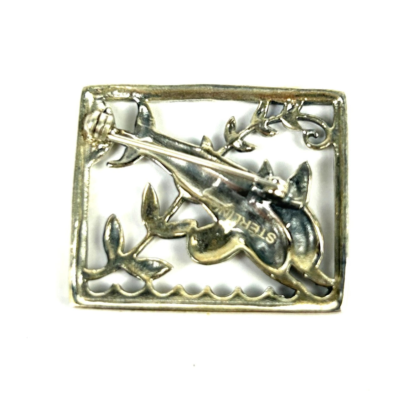 A STERLING SILVER DOLPHIN BROOCH.