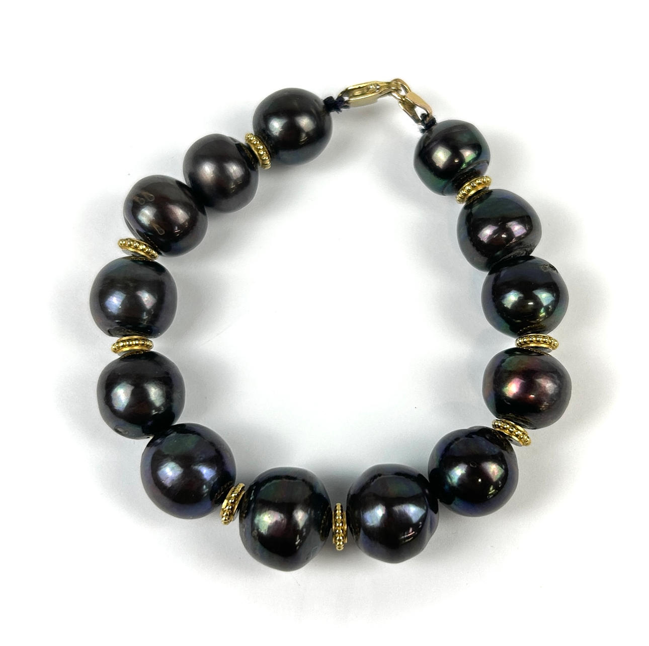9CT GOLD AND BLACK PEARL BRACELET.