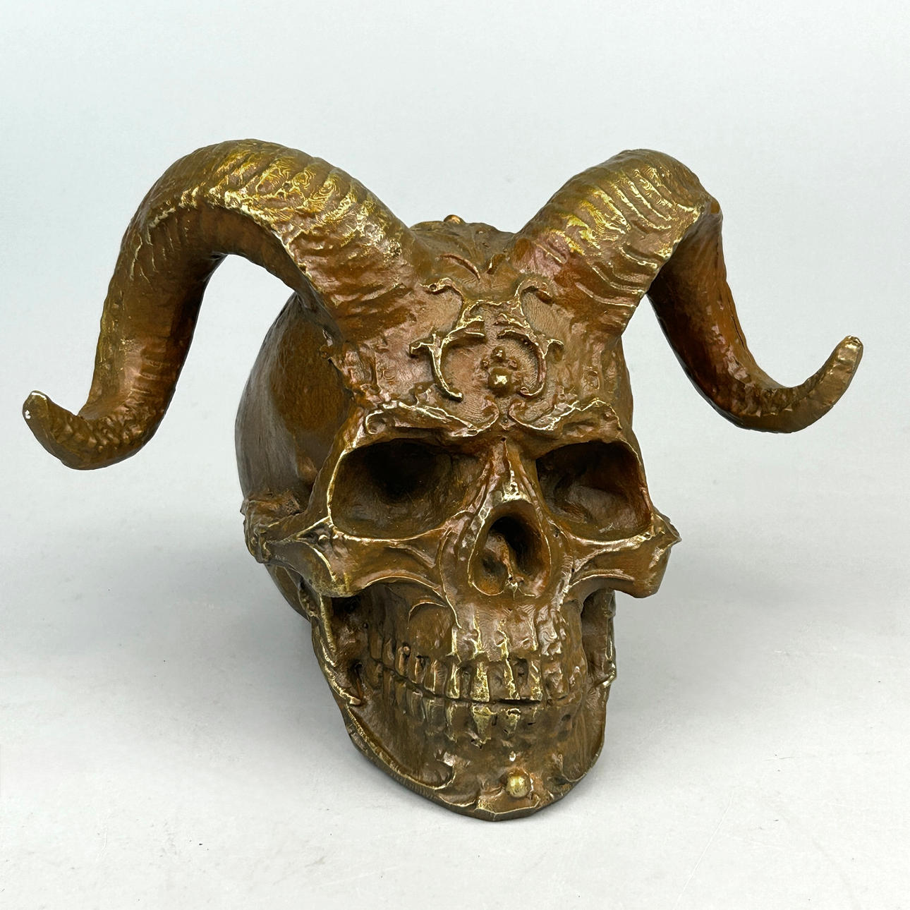 A BRONZE SKULL AND HORNS SCULPTURE.