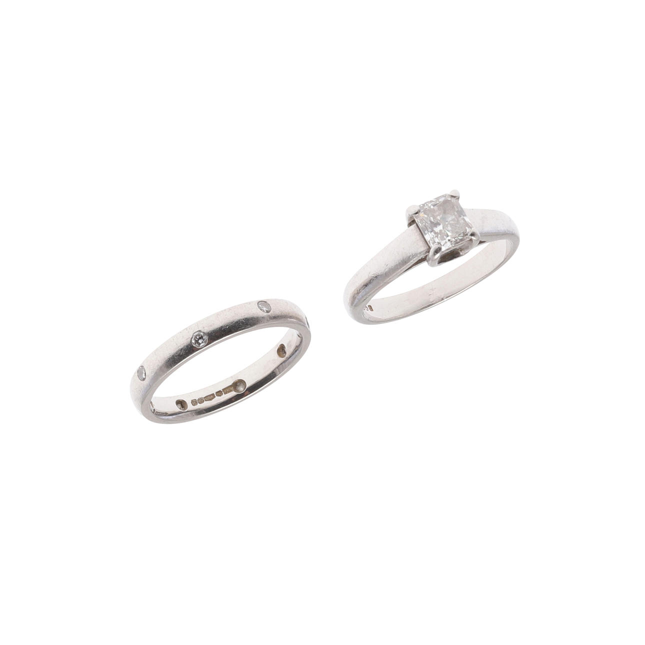 A PLATINUM AND DIAMOND SOLITAIRE RING AND WEDDING BAND.