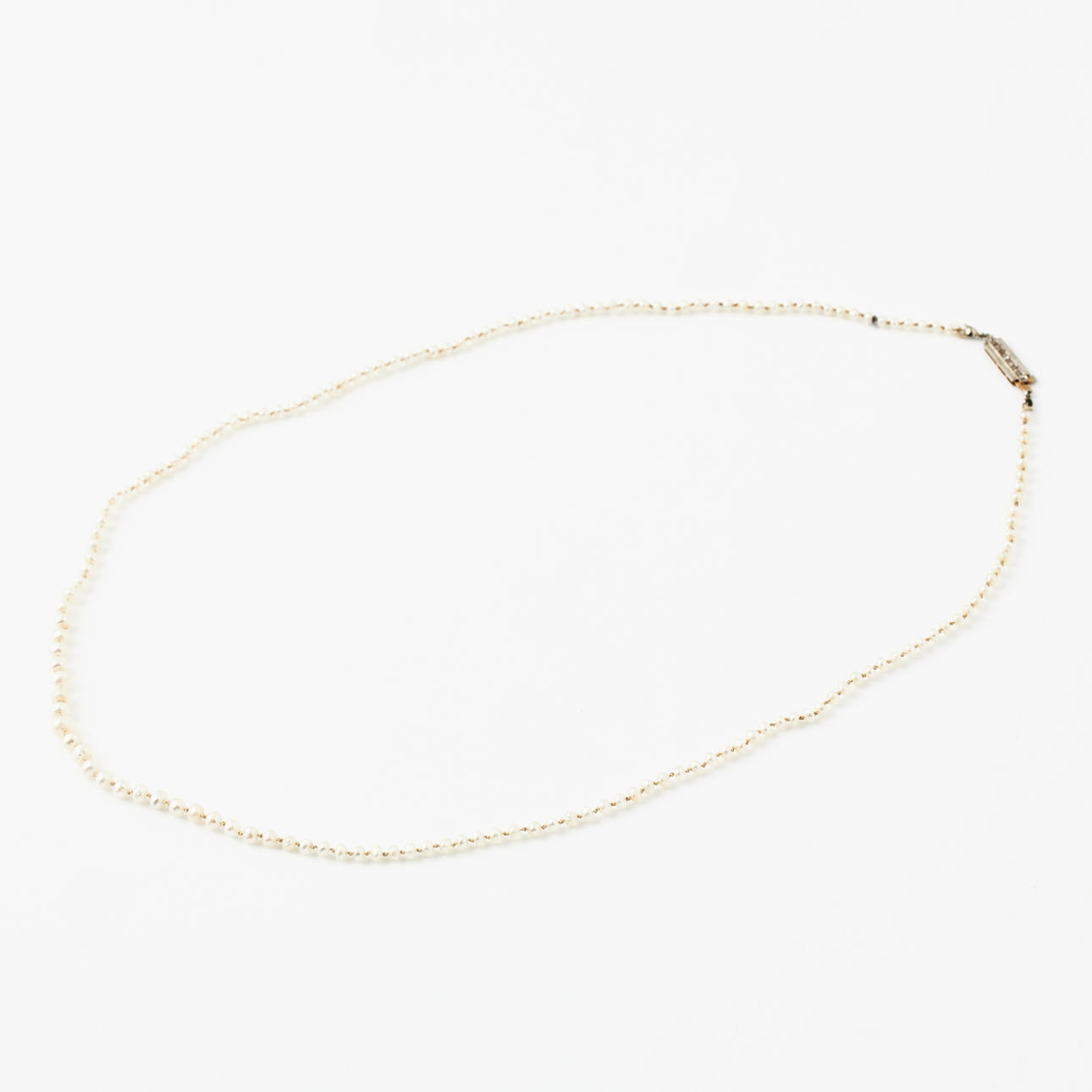 A necklace, metered, possibly orientated pearls, rectangular clasp, 18k gold, decoration with 7 small rose-cut diamonds in platinum mounting, Juvelerare AB J Petterssons Eftr., Stockholm 1938.