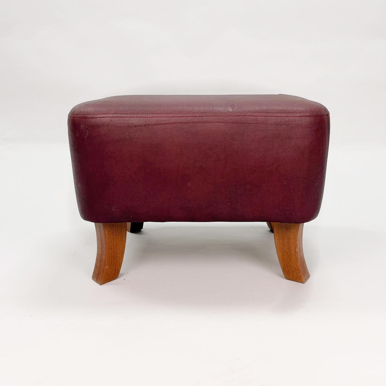 FOOTSTOOL - Leather with wooden legs.