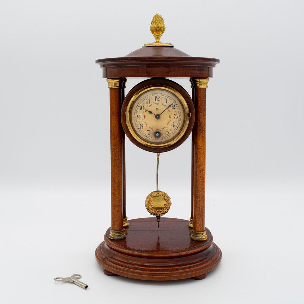 JUNGHANS FIREPLACE CLOCK, MAHOGANY COLORED, STAINED BEECH, BRASS PENDULUM, AROUND 1900, WITH KEY.