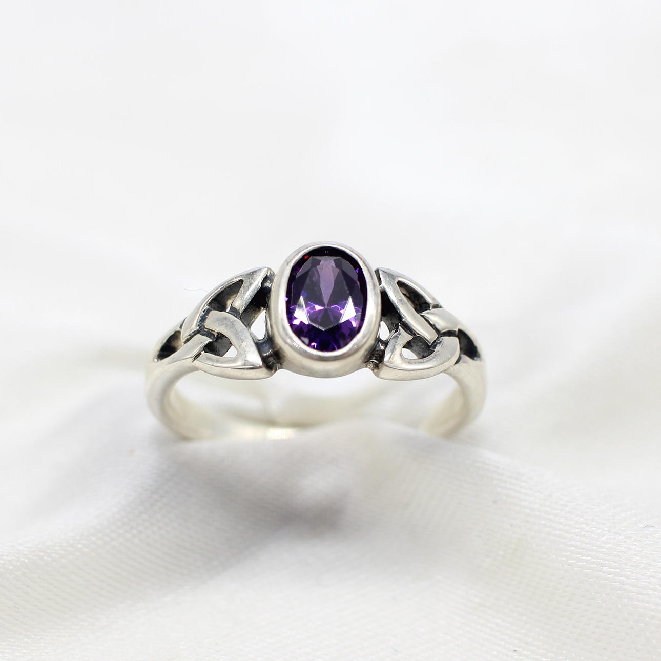 SILVER CELTIC RING WITH PURPLE CUBIC ZIRCONIA.
