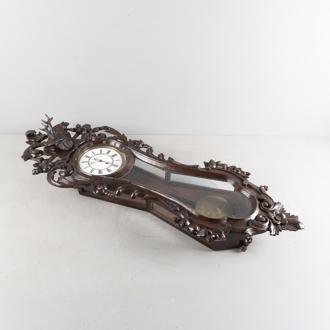 A wall clock, cut case with deer decor, dark stained oak, late 19th ...