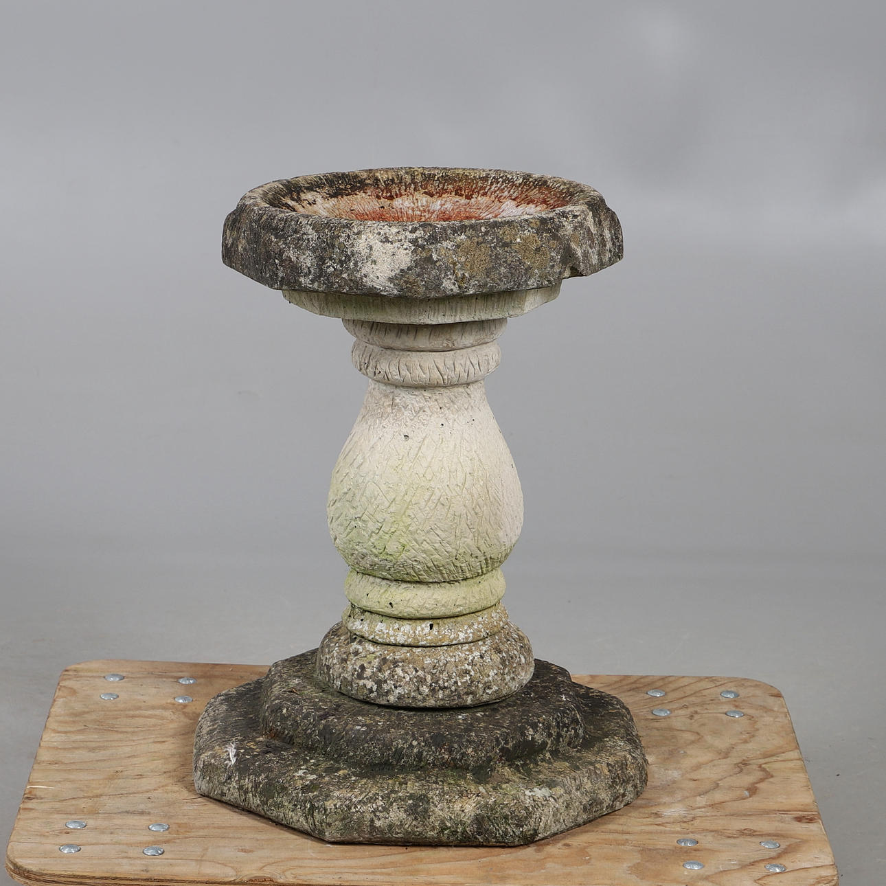 A RECONSTITUTED STONE OCTAGONAL BIRD BATH.