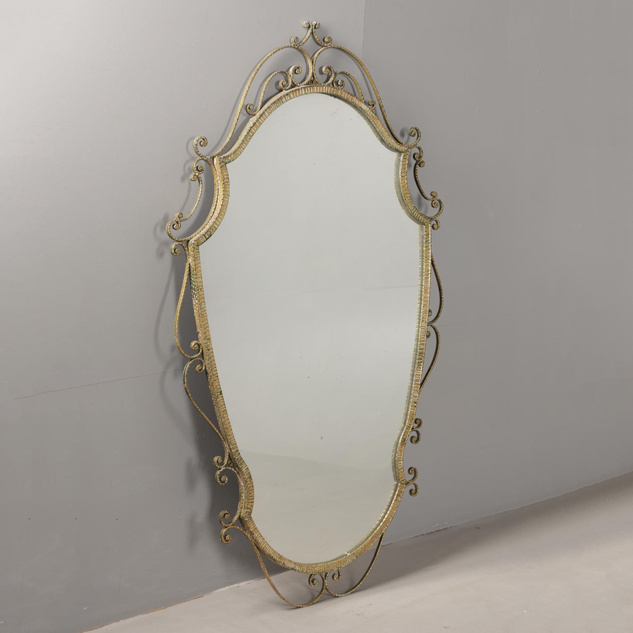 A LARGE GILT METAL WALL MIRROR.