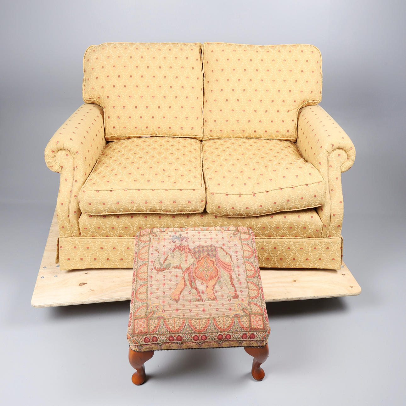 FABRIC TWO-SEATER SOFA AND A FOOTSTOOL. (2).