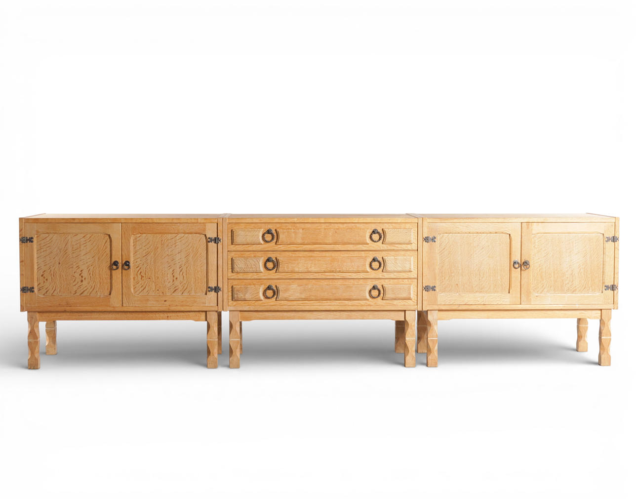 Drei niedrige Sideboards aus Eichenholz, Front mit Türen und Schubladen, Beine mit Ausschnitten, Metallklammern. Henry Kjærnulf-Stil. Dänemark, 1960-70er Jahre (3). Möbel - Schränke & Regale