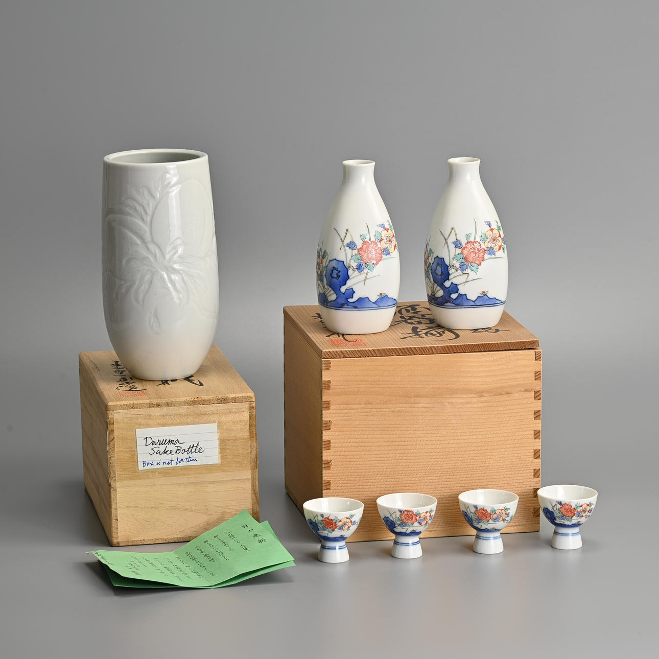 A PAIR OF JAPANESE ARITA KAKIEMON SAKE BOTTLES (TOKKURI) AND FOUR CUPS ...