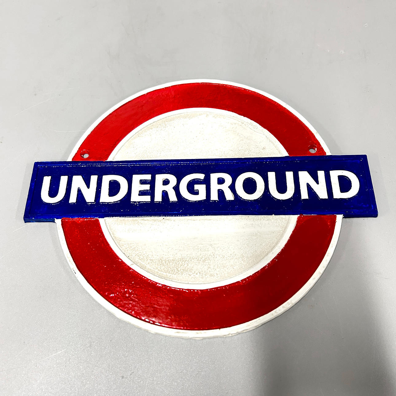 A PAINTED CAST IRON SIGN.