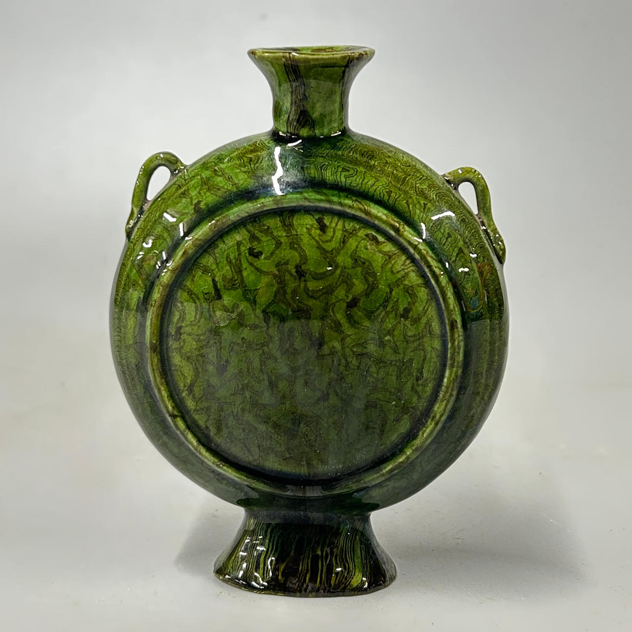 A GREEN MARBLE GLAZED POTTERY MOON VASE.
