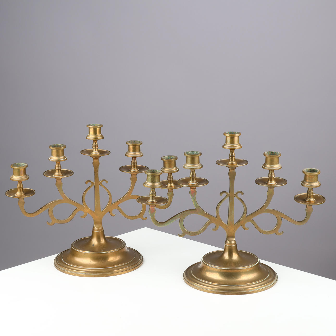 A pair of brass five-armed candlesticks, circa 1920s, (2).