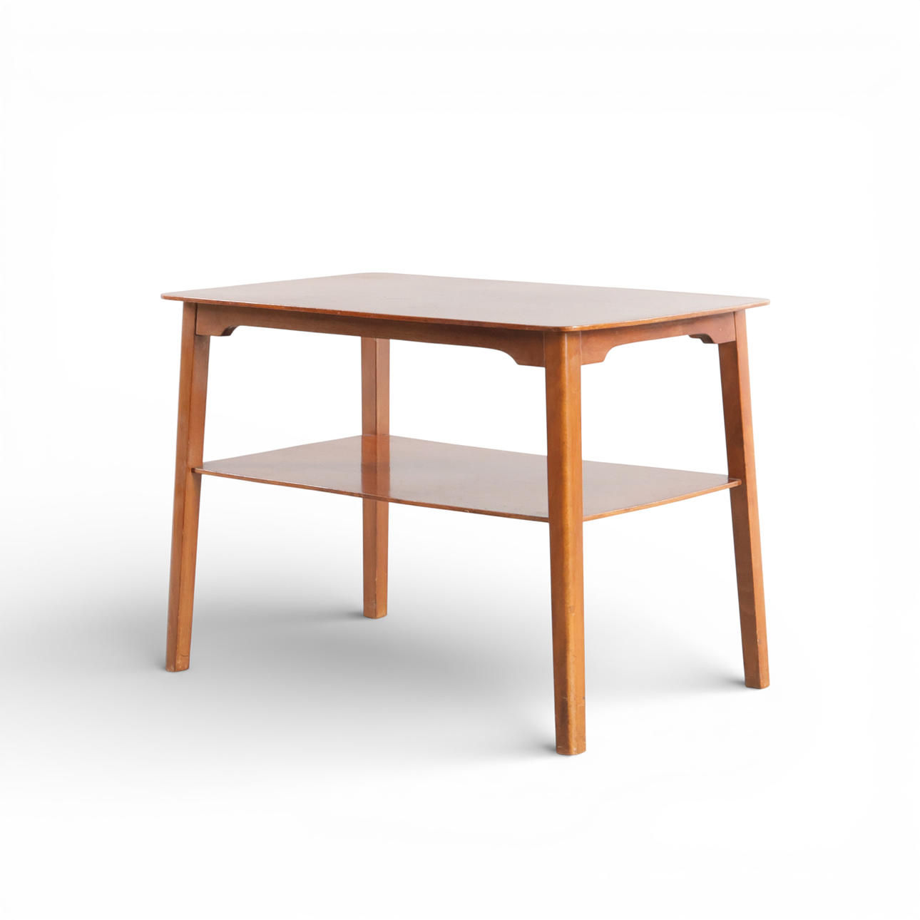 Rectangular coffee table with rounded corner, including shelf, tapered inclined legs. Probably done by Fritz Hansen. Denmark, 1950s.