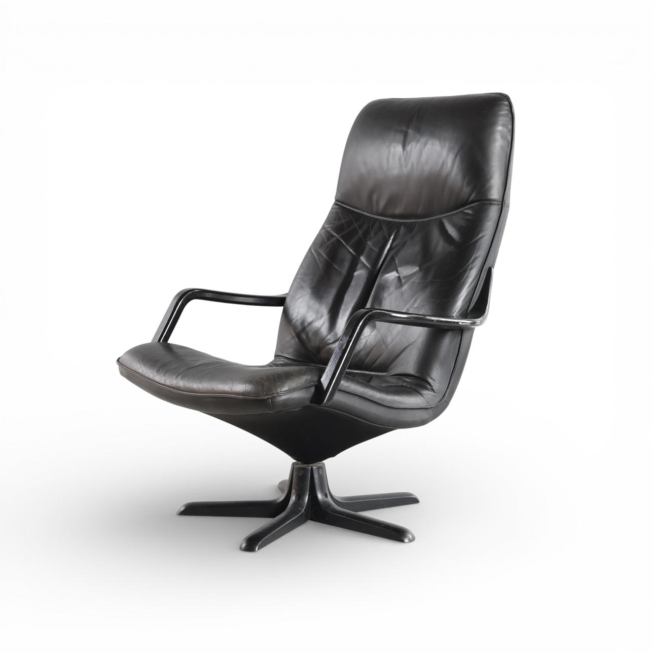 High-back armchair upholstered in leather, adjustable back, armrests and five-fold foot made of black lacquered wood. Manufactured at Berg Furniture.