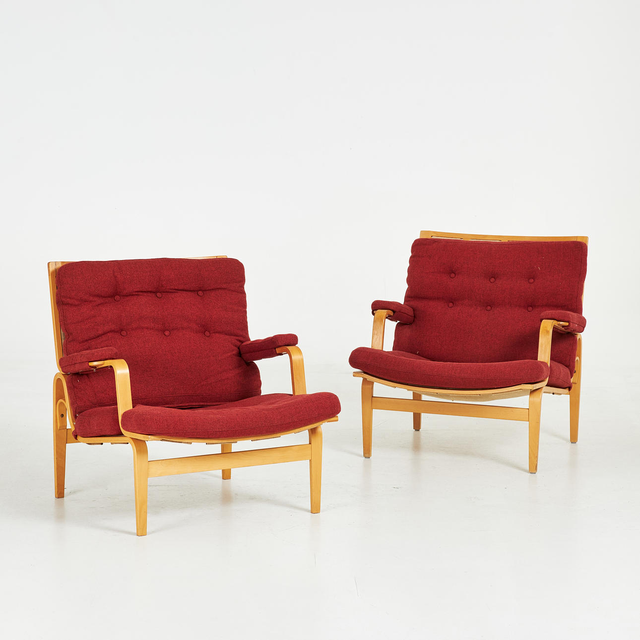 BRUNO MATHSSON. Armchairs, 1 pair, “Ingrid”, Dux, laminated frame in beech, red wool upholstery, upholstered deep sewn buttons.