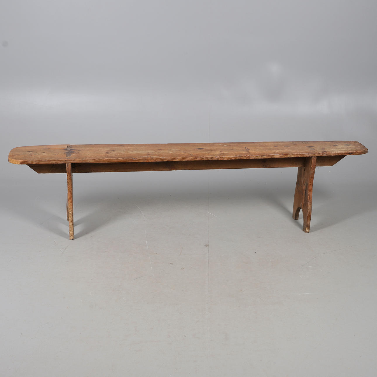 A STRIPPED AND WAXED PINE BENCH SEAT.