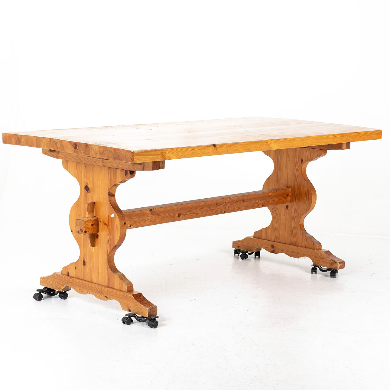 A late 20th century solid pine trestle table.