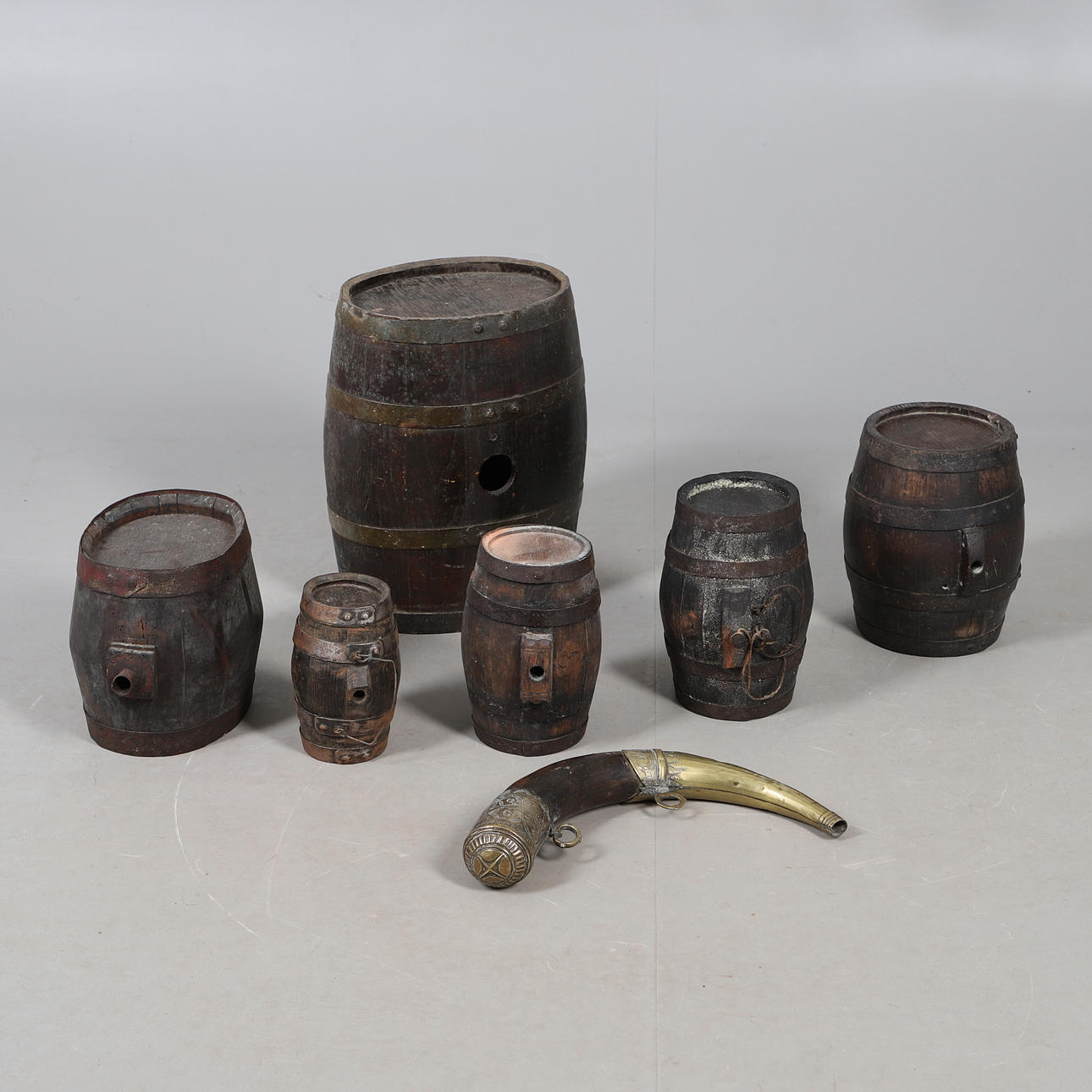 A COLLECTION OF POWDER OR SIMILAR BARRELS AND A BRASS MOUNTED POWDER ...