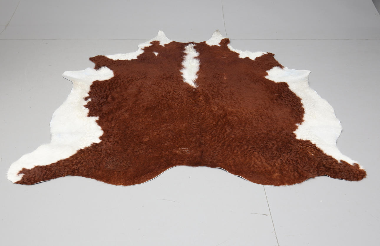 KOHUD, vit och brun. Cirka 200 x 180 cm.