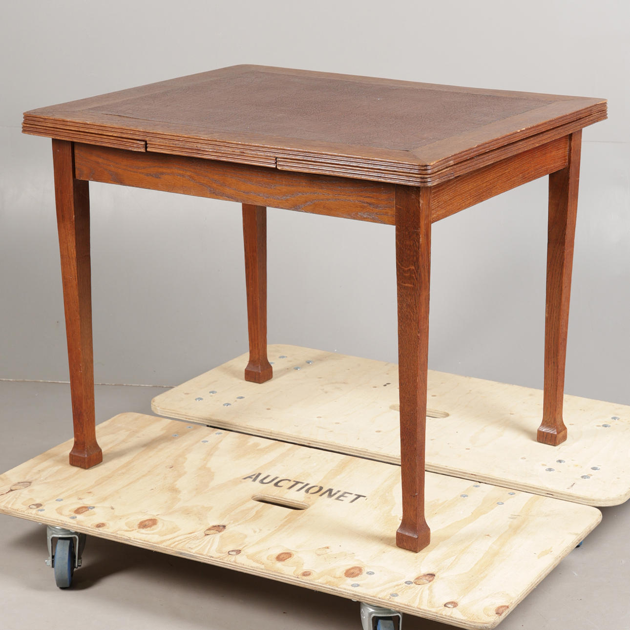 AN OAK AND LEATHER TOPPED DRAW LEAF TABLE.