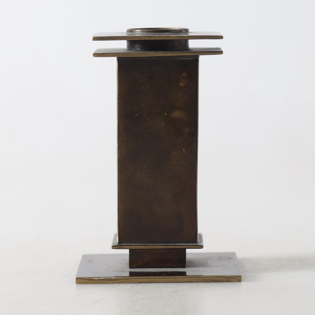 A candlestick, patinated brass, 20th century.