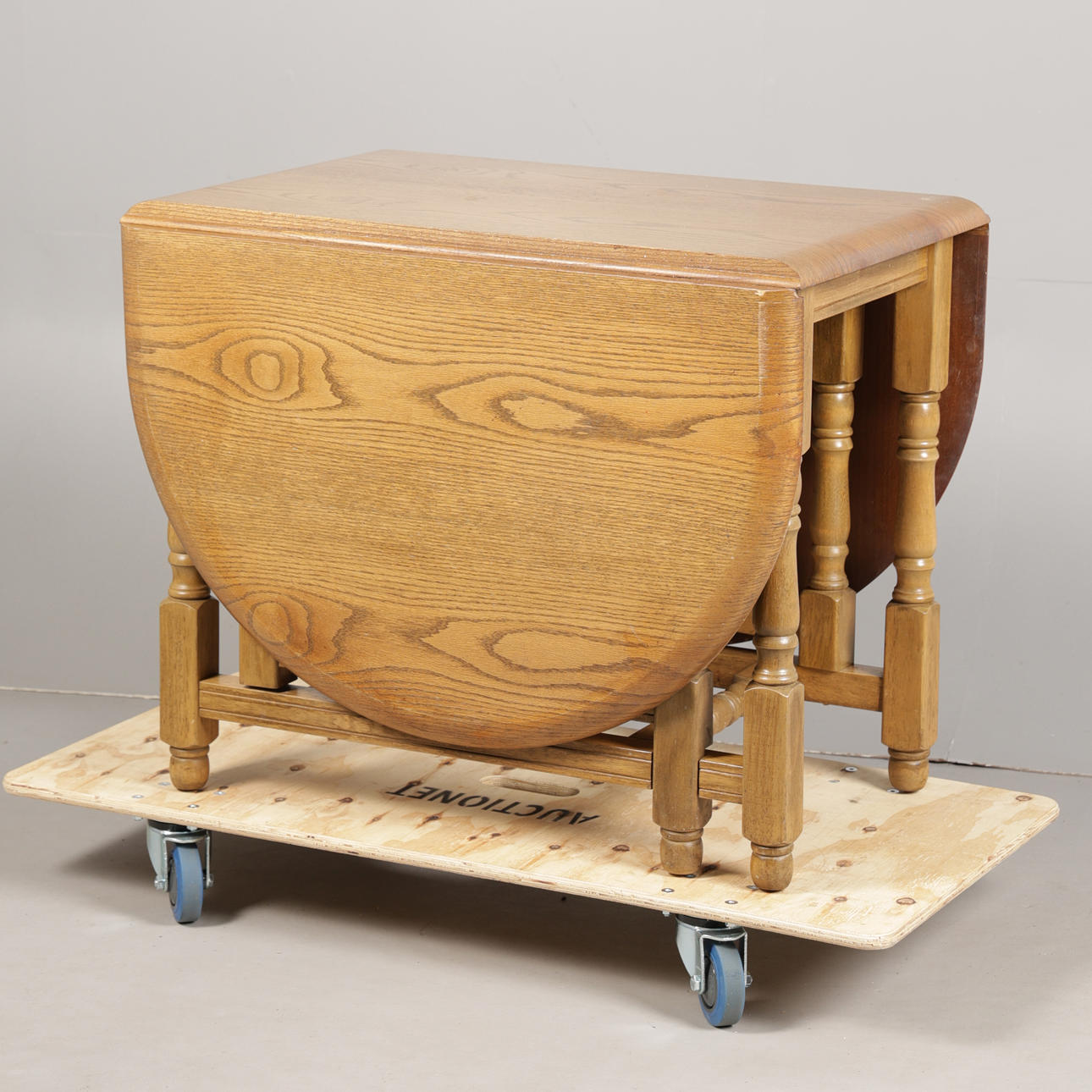 A LIGHT OAK DROP LEAF TABLE.