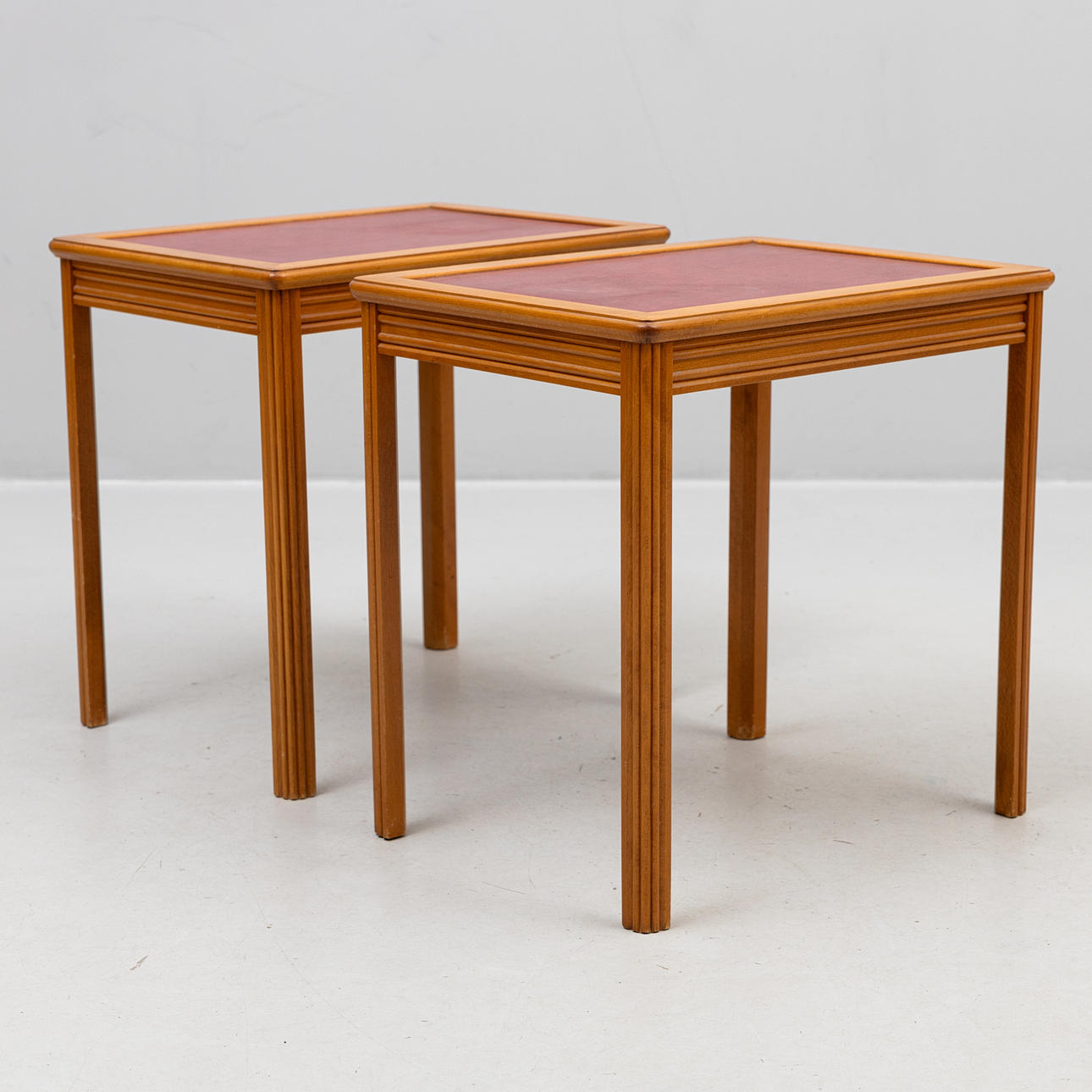 A pair of side tables, dressed disc, a label marked EJM.