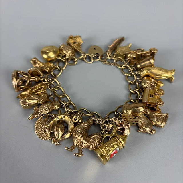 9CT GOLD CHARM BRACELET WITH CHARMS.