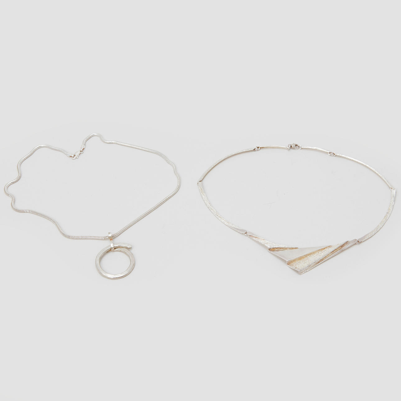 A pair of silver necklaces.