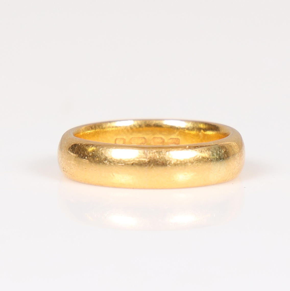 A 22 CARAT GOLD WEDDING RING.