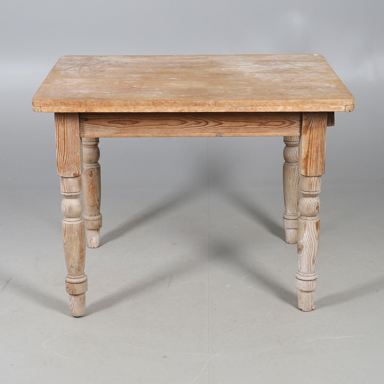 A STRIPPED PINE KITCHEN TABLE.